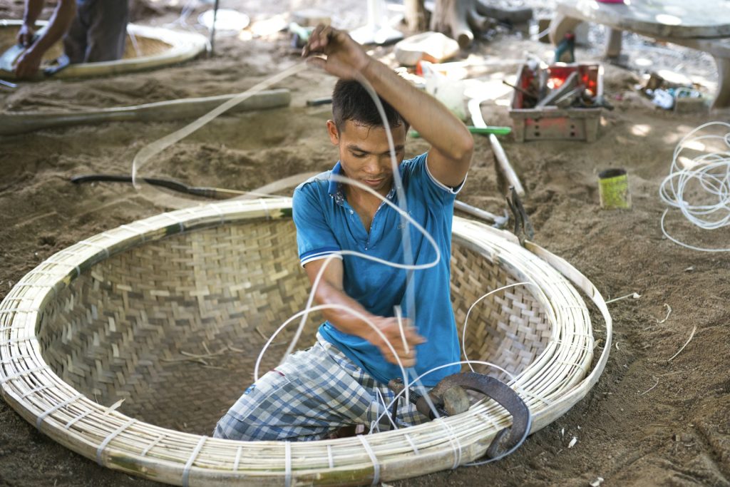 a man sitting inside of a woven basket